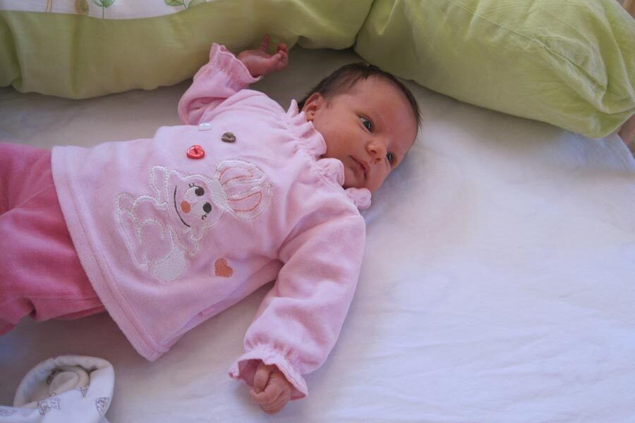 La piccola Katharina è vestita di rosa e giace nel suo letto.