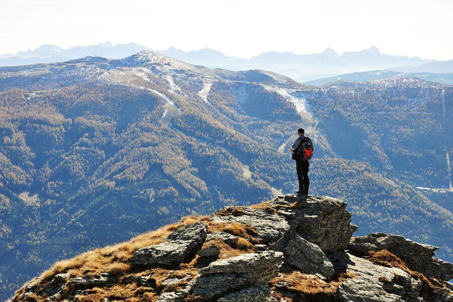 A hiker at the summit of a mountain in the Nockberge mountains in Carinthia.