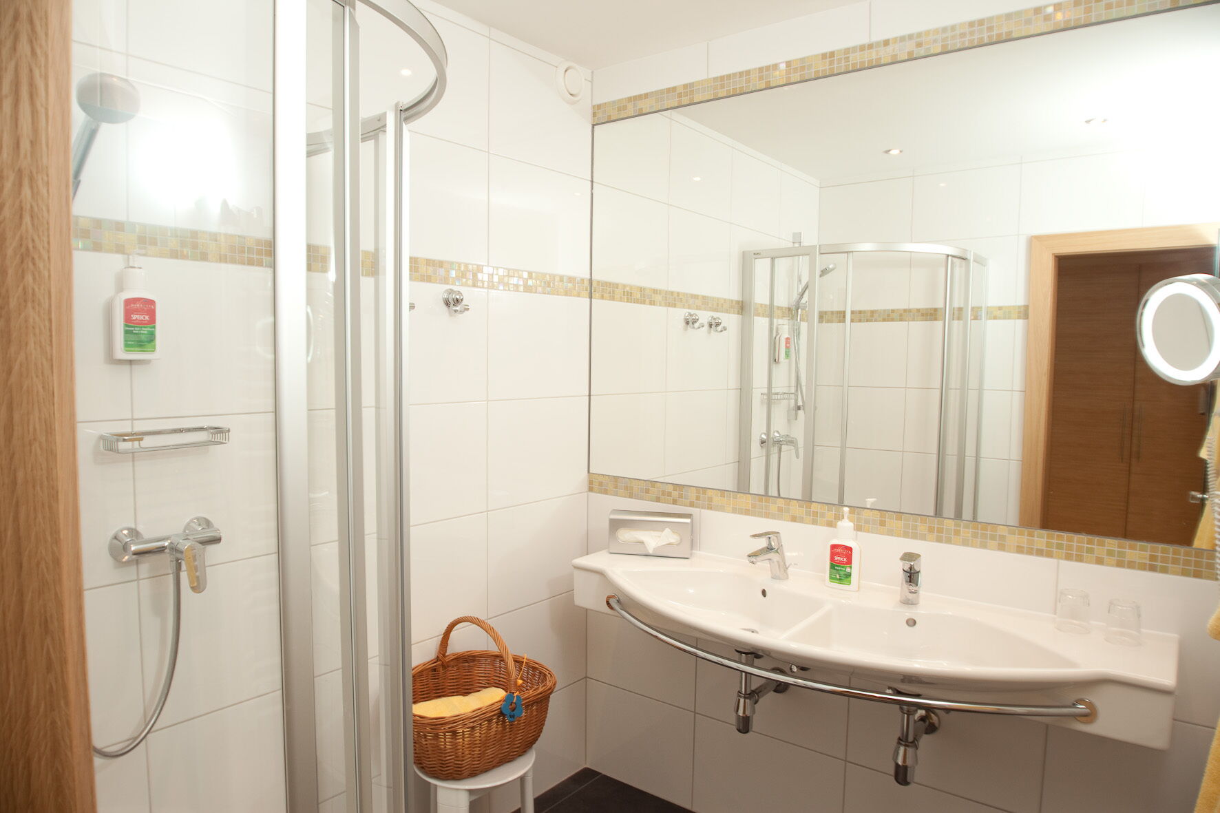 Ein modernes Spa-Badezimmer mit Duschbereich und Doppelwaschbecken zur Entspannung.
