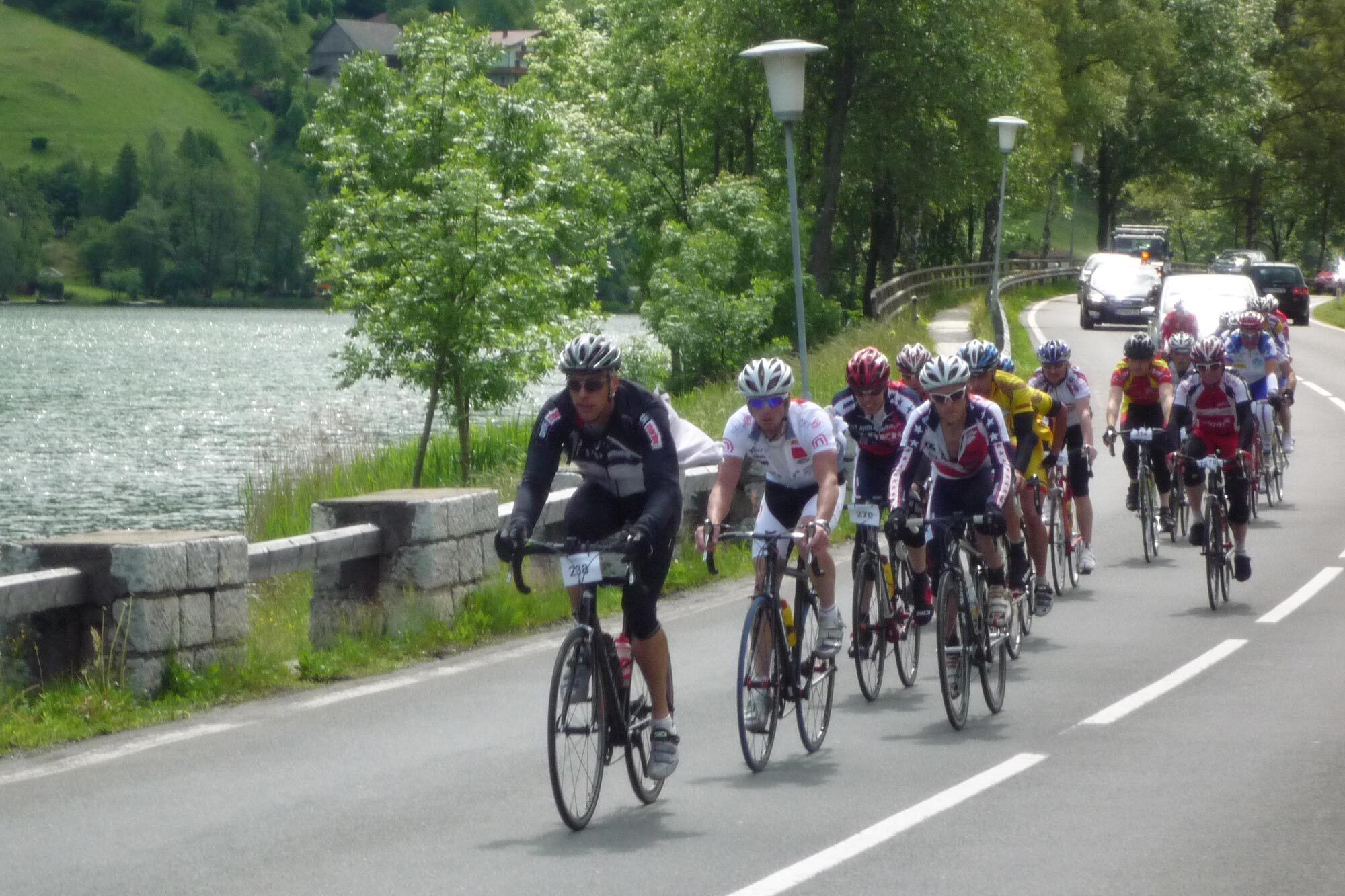 Gruppe von Radfahrern auf einer schönen Straße am Wasser, umgeben von Natur. Ein Outdoor-Abenteuer in Kärnten.