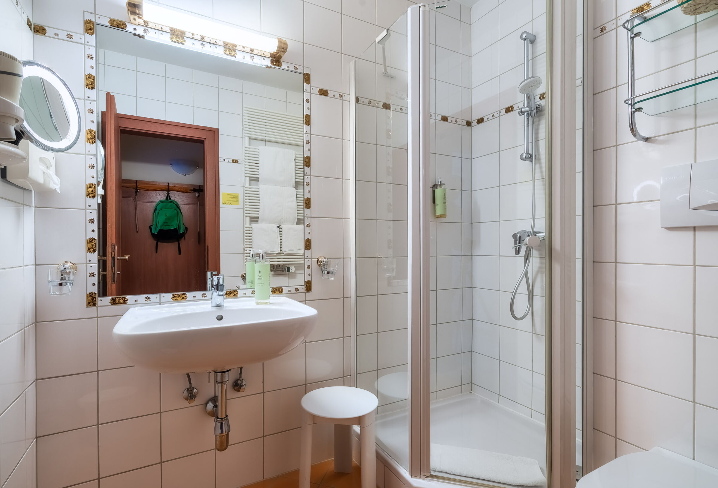 Modernes Spa-Badezimmer mit Duschbereich und minimalistischem Design aus weißen Fliesen