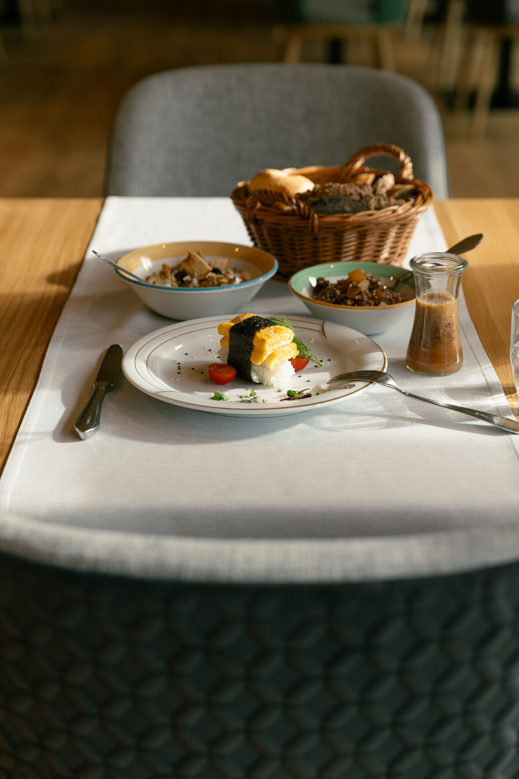 Eleganter Tisch mit sorgfältig angerichtetem Gourmetgericht und Beilagen in einer stilvollen Restaurantumgebung.