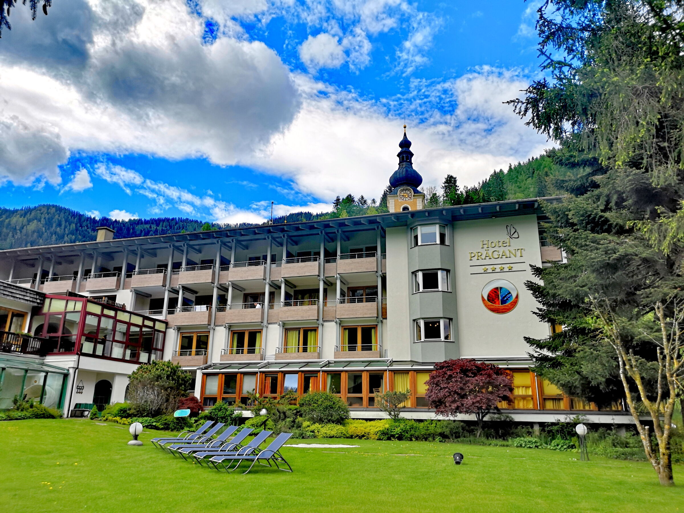 Moderne Architektur des Wellnesshotels umgeben von Bergen und Naturflächen in Bad Kleinkirchheim.