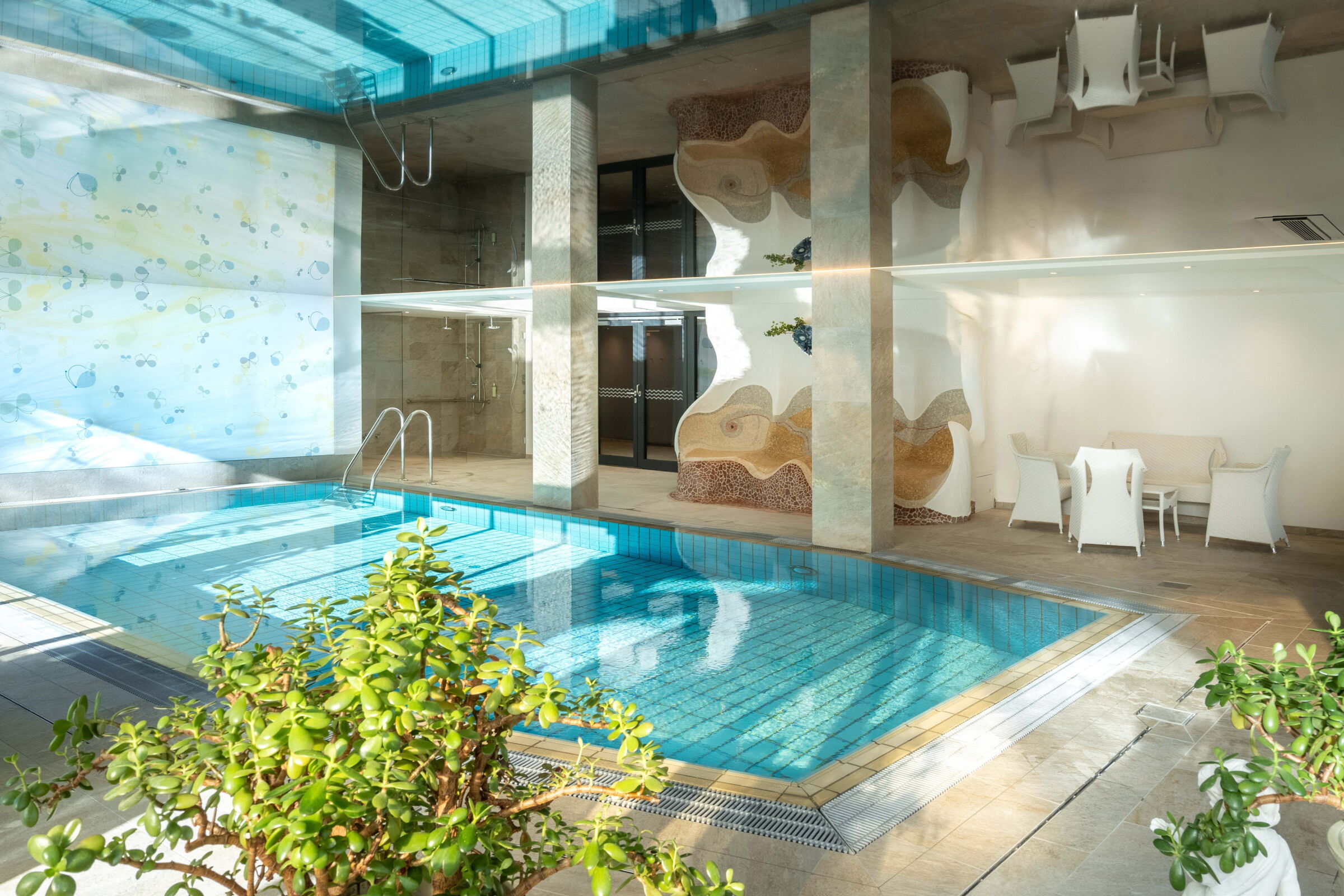 Innenansicht des Spa-Bereichs mit einem Swimmingpool und einer Ruhezone im Hintergrund.
