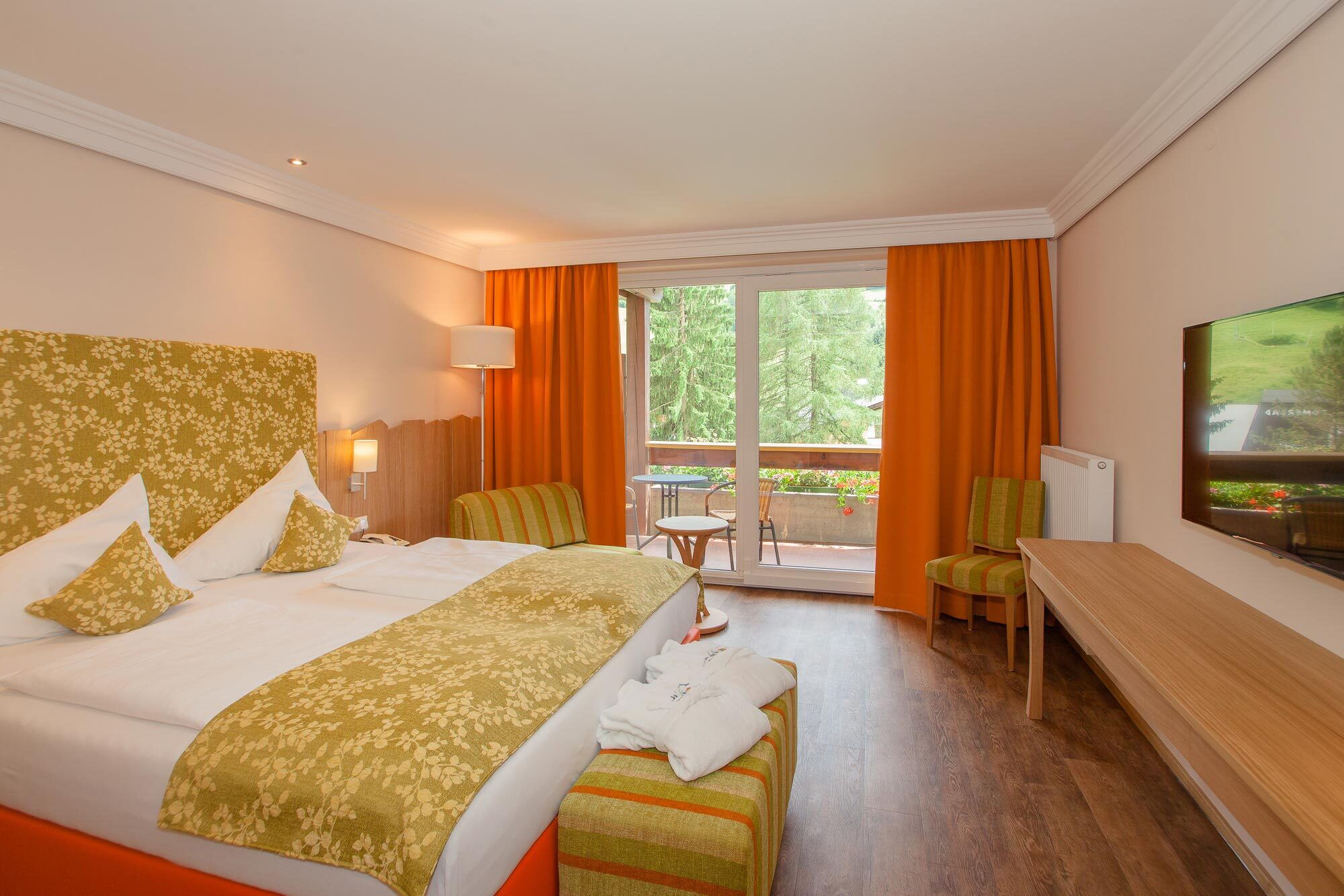 Ein einladender Spa-Raum mit Doppelbett und gemütlicher Sitzecke, durchflutet von natürlichem Licht.