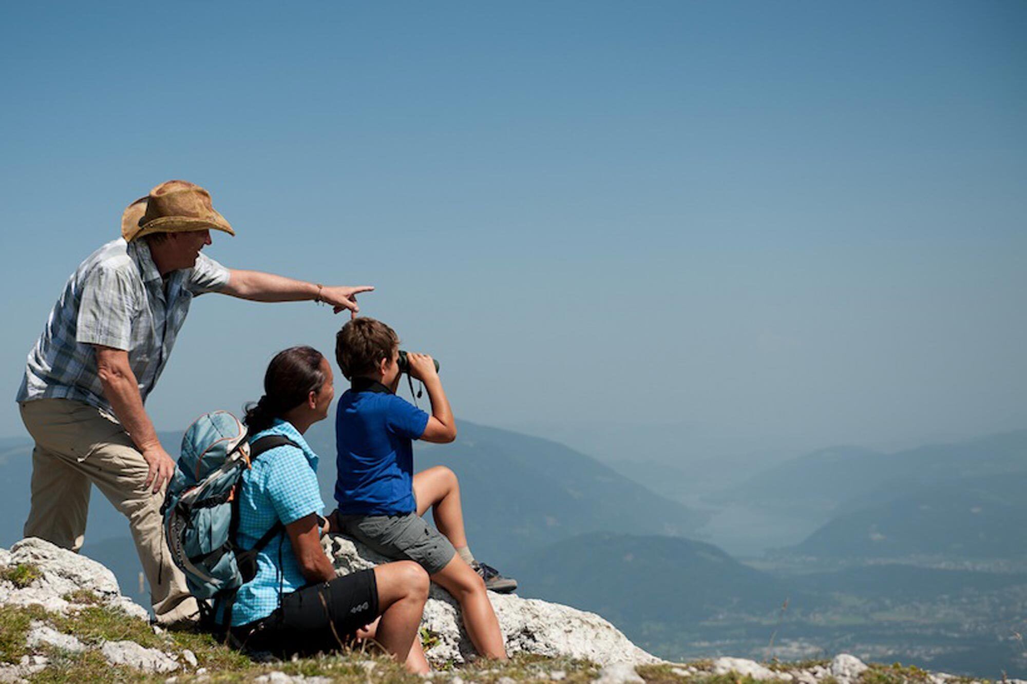 Two adults and a child on a discovery tour on a mountain in Carinthia