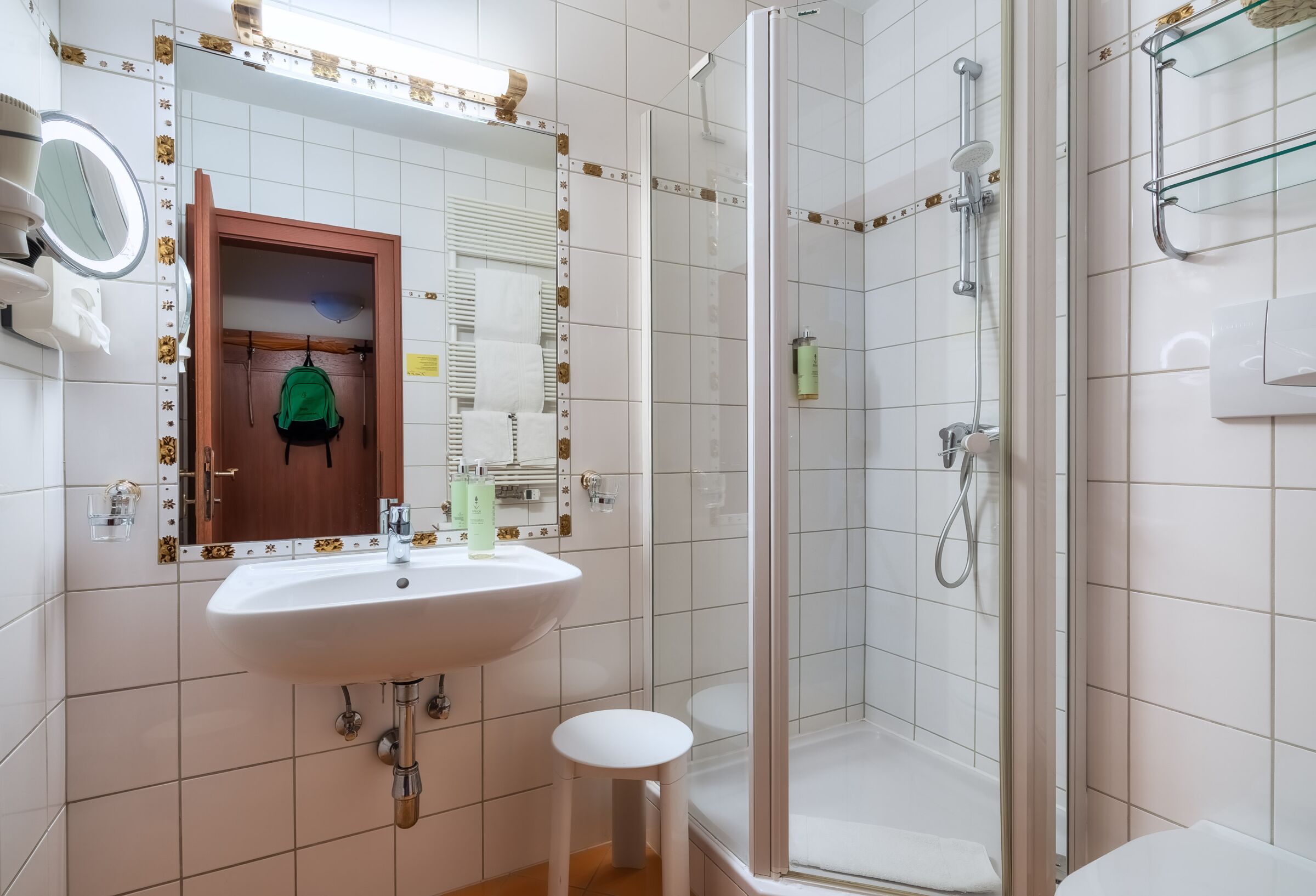 Modernes Spa-Badezimmer mit Duschbereich und minimalistischem Design aus weißen Fliesen