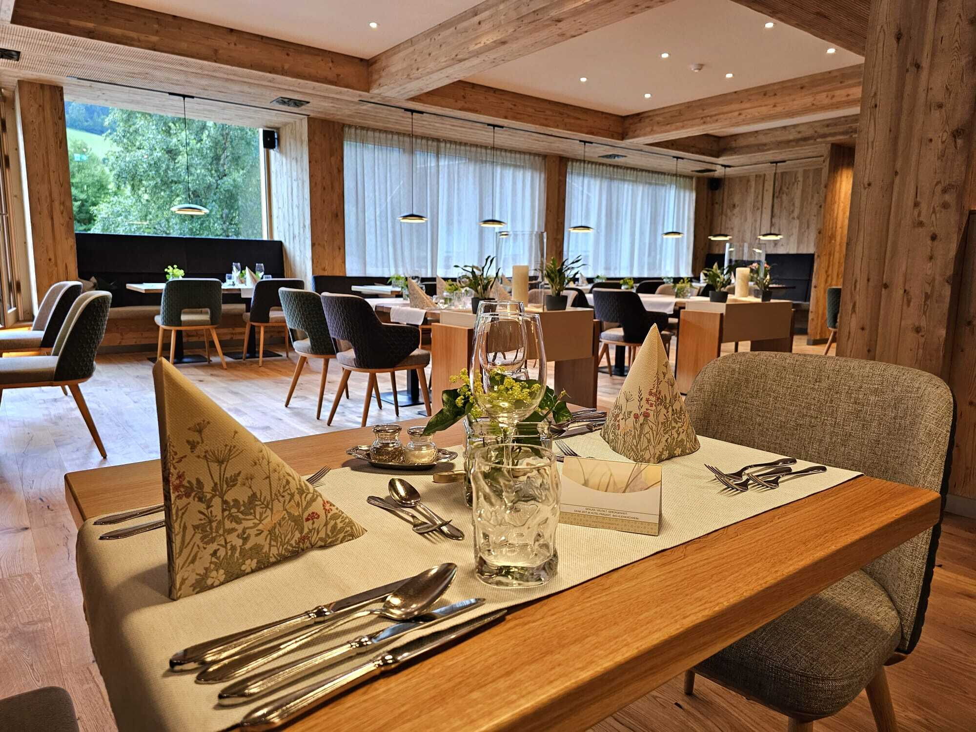 Ein einladender Essbereich in einem Spa-Restaurant mit Blick ins Grüne und Holzelementen.