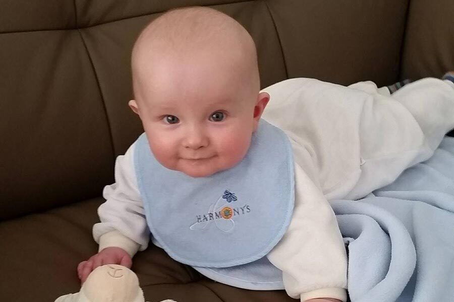 Il piccolo Benni sdraiato su una coperta a pancia in giù.