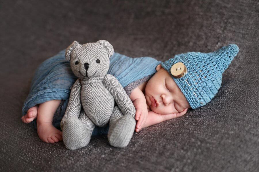 Il piccolo Stephan che dorme e un orsacchiotto di peluche accanto a lui.