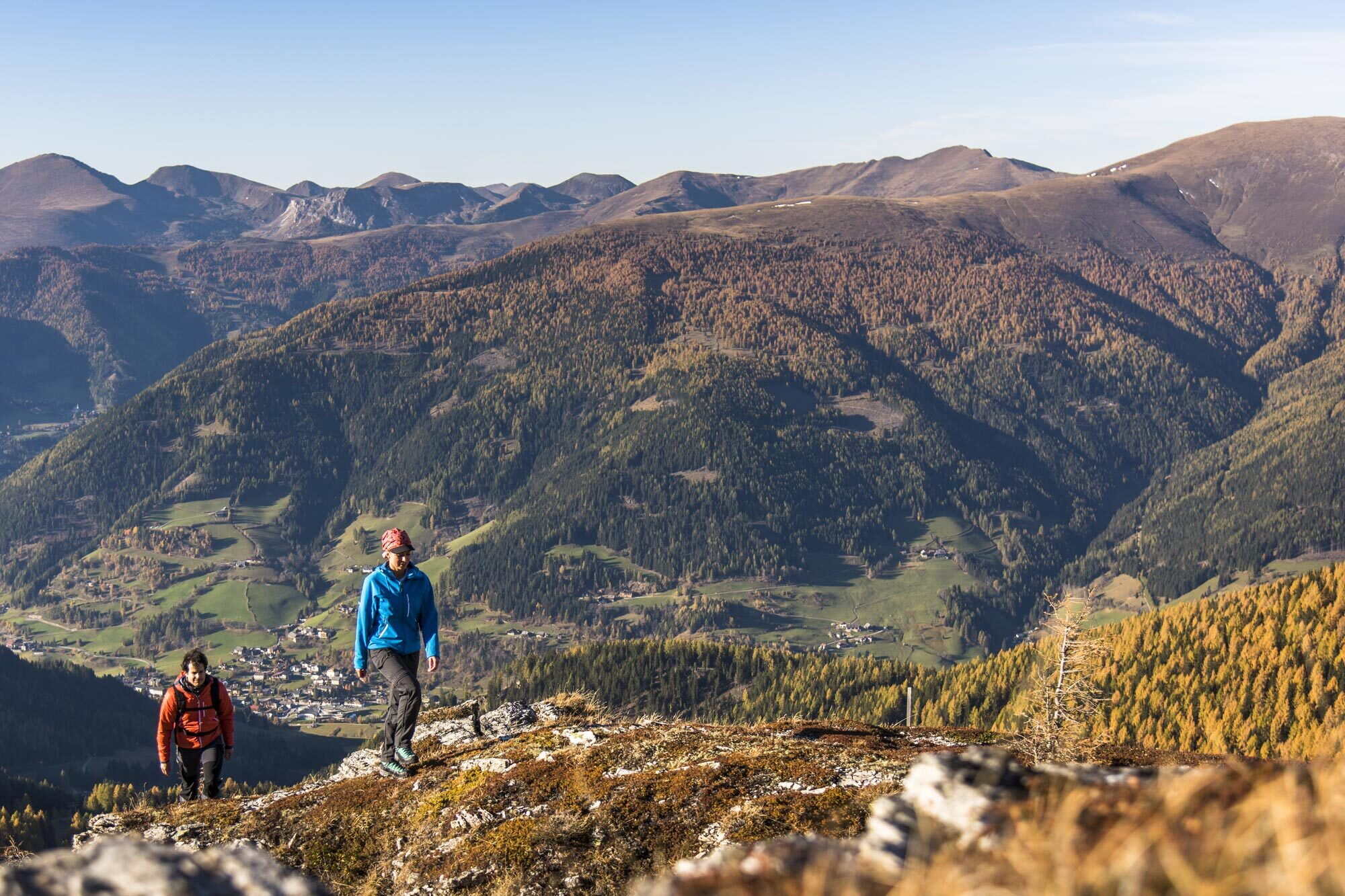 Zwei Wanderer erkunden einen felsigen Pfad mit Blick auf eine weite Berglandschaft