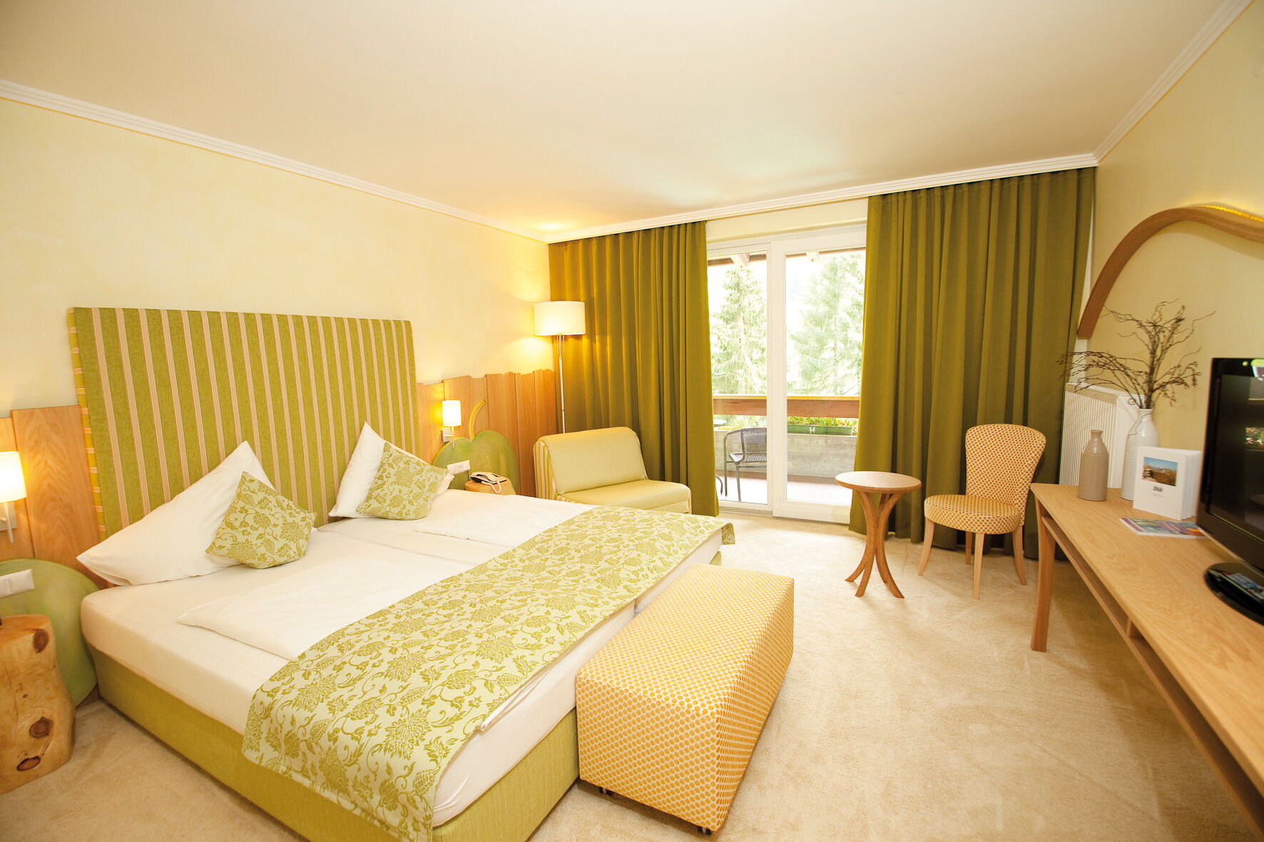 Ein einladender Spa-Raum mit einem Bett, einer Sitzecke und großen Fenstern für Tageslicht.
