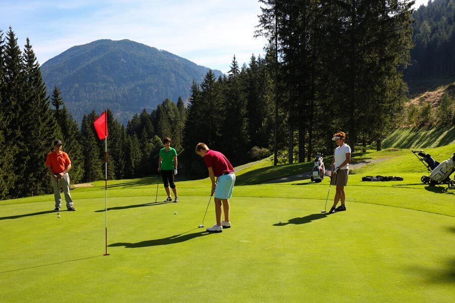 Golfers on a golf course in the Carinthian mountains