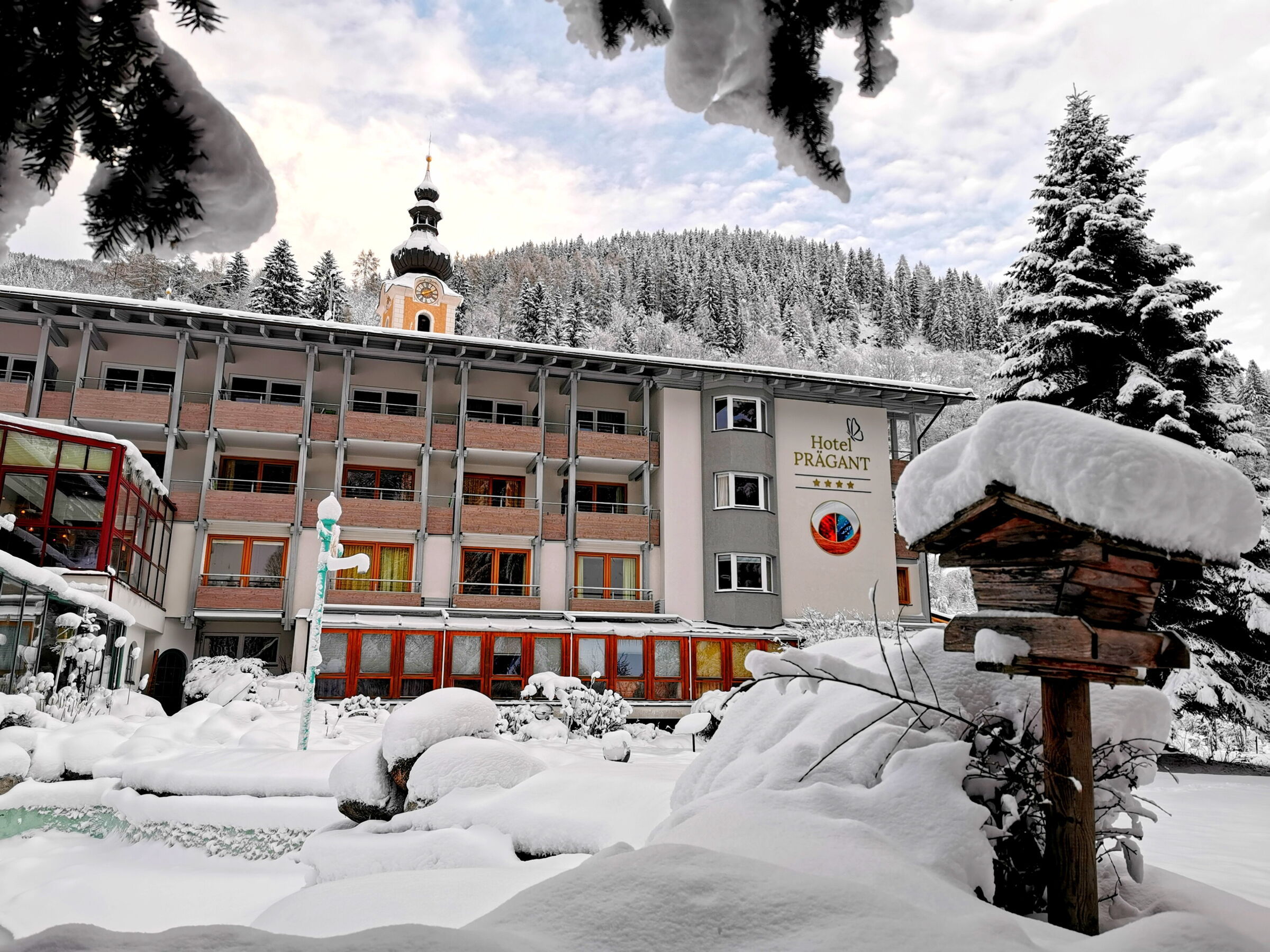 Spa Hotel umgeben von schneebedeckten Bäumen in einer Winterlandschaft mit Bergen im Hintergrund