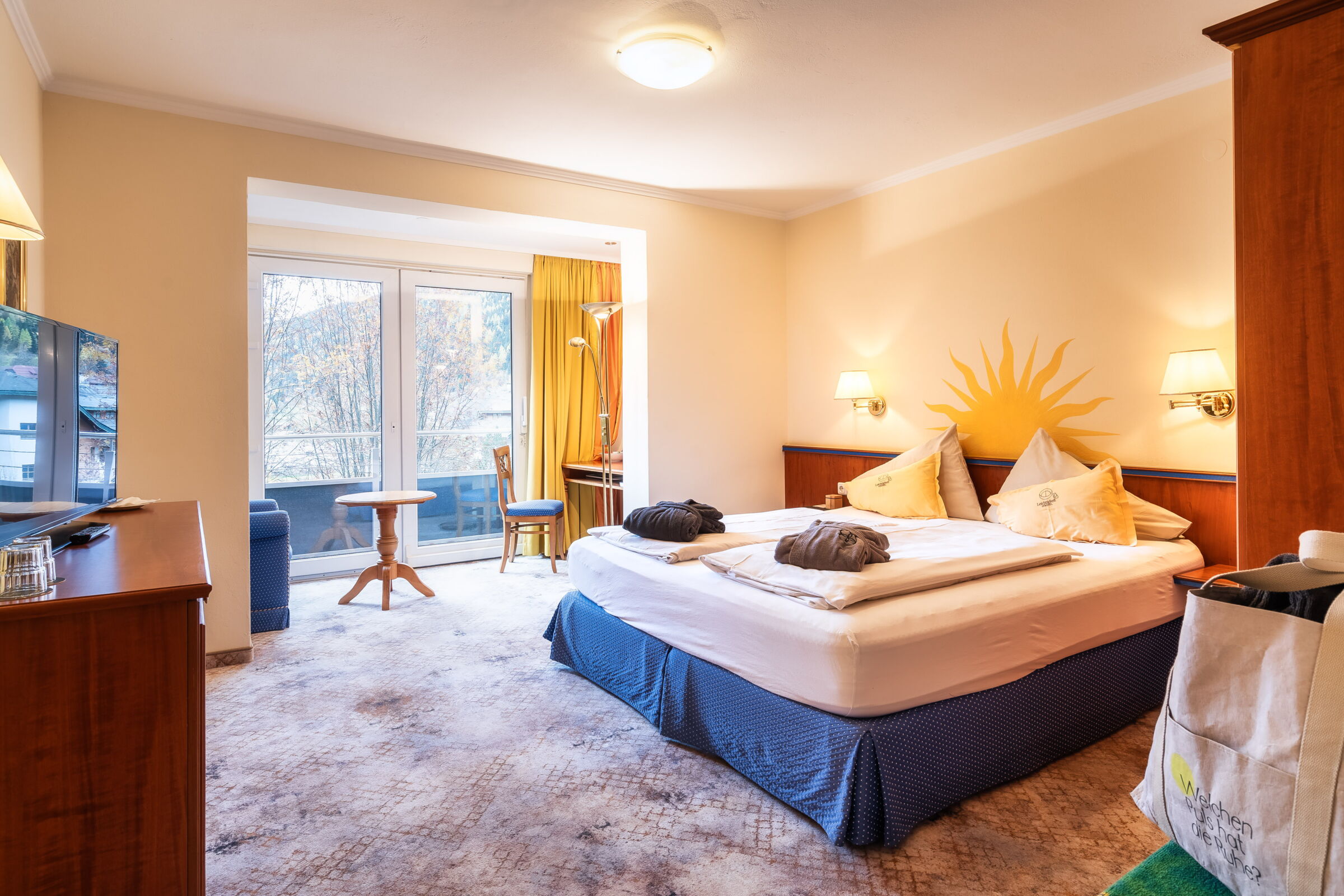 Ein stilvolles Spa-Zimmer mit großem Bett und Sitzgelegenheit, hell durch Tageslicht