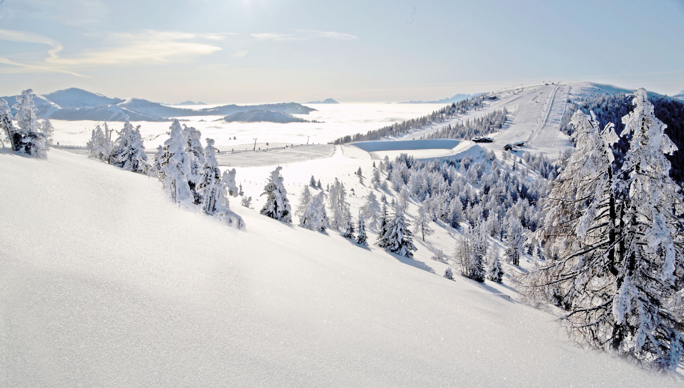 Winterliche Berglandschaft mit verschneiten Bergen und Bäumen unter klarem Himmel