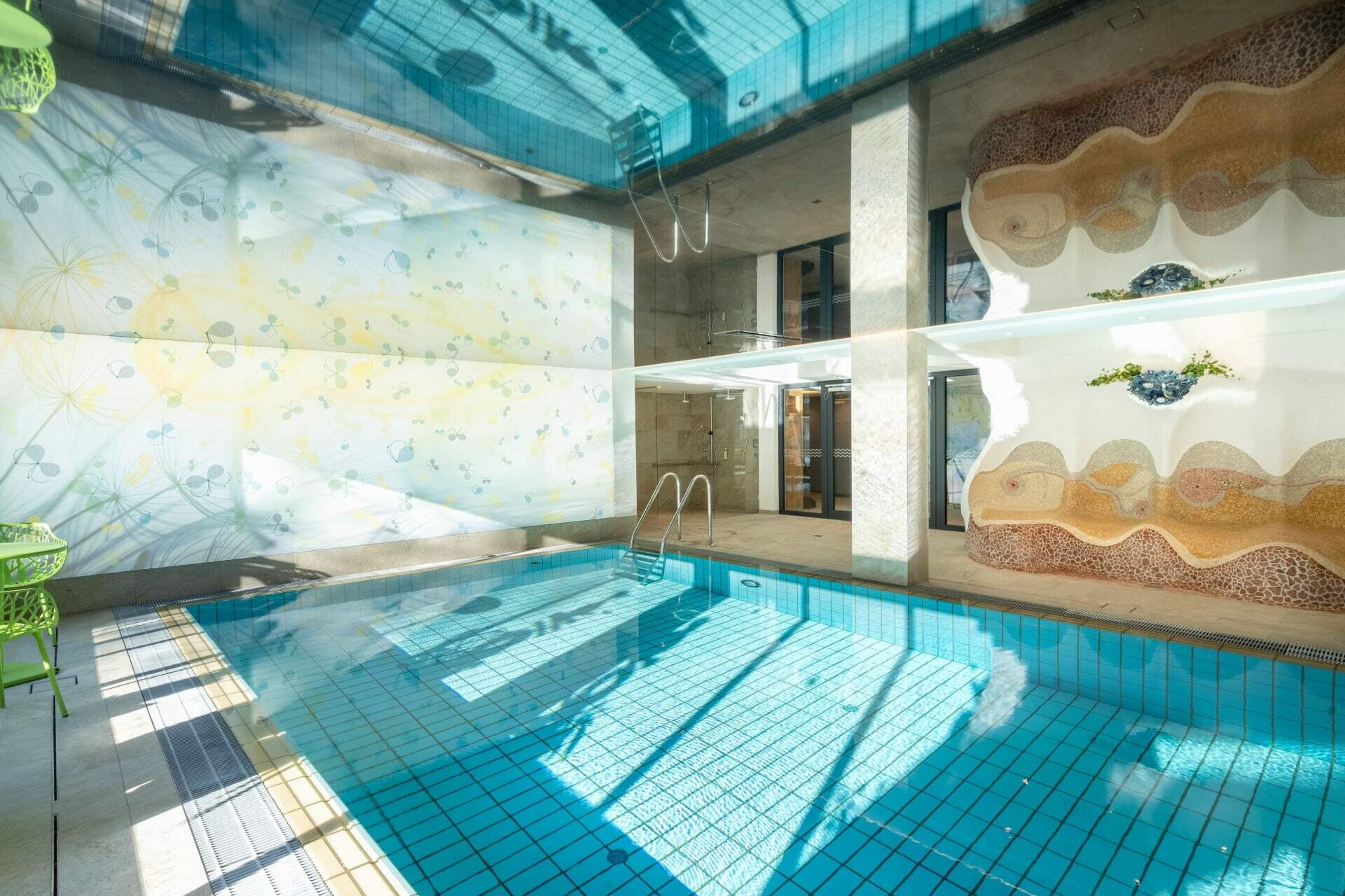 Moderner Innenpool mit reflektierender Wasseroberfläche und zeitgenössischer Dekoration