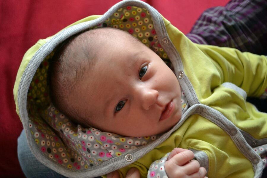 La piccola Victoria Amelie tenuta in braccio da una sola persona.