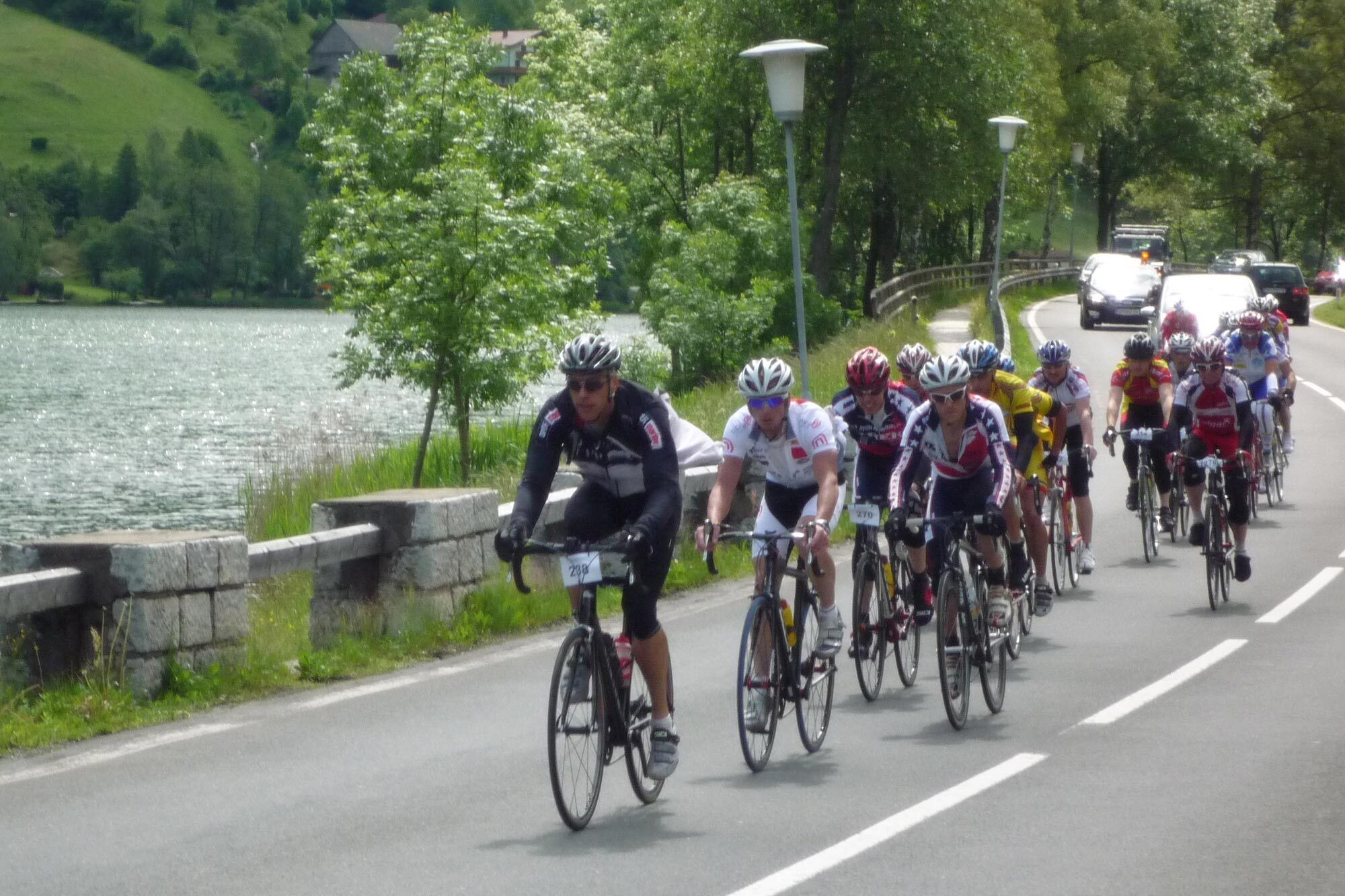 Gruppe von Radfahrern auf einer schönen Straße am Wasser, umgeben von Natur. Ein Outdoor-Abenteuer in Kärnten.
