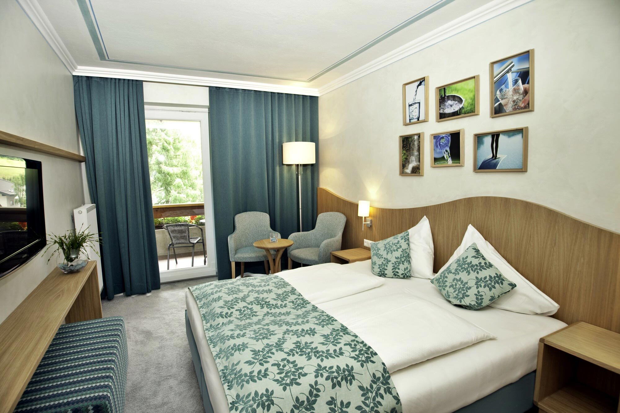 Gemütlicher Spa-Raum mit einem Bett und einer Sitzgelegenheit, reichlich Tageslicht durch große Fenster.