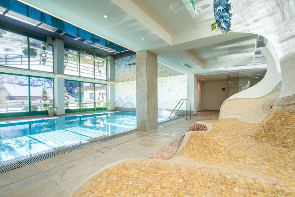 Ein entspannender Innenpool mit natürlichem Licht und modernen Sitzgelegenheiten im Spa-Bereich.