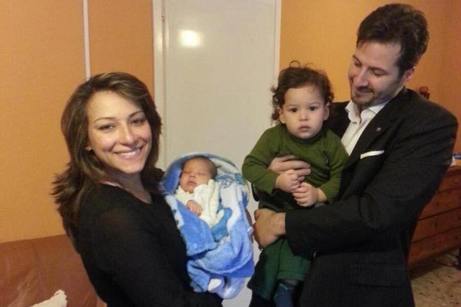 Baby Andrea and Raul being held by their parents.