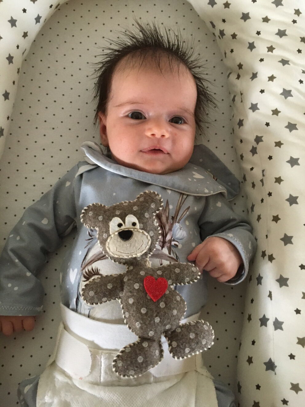 La piccola Melina Magdalena sdraiata in un cuscino per bambini e sorridente.