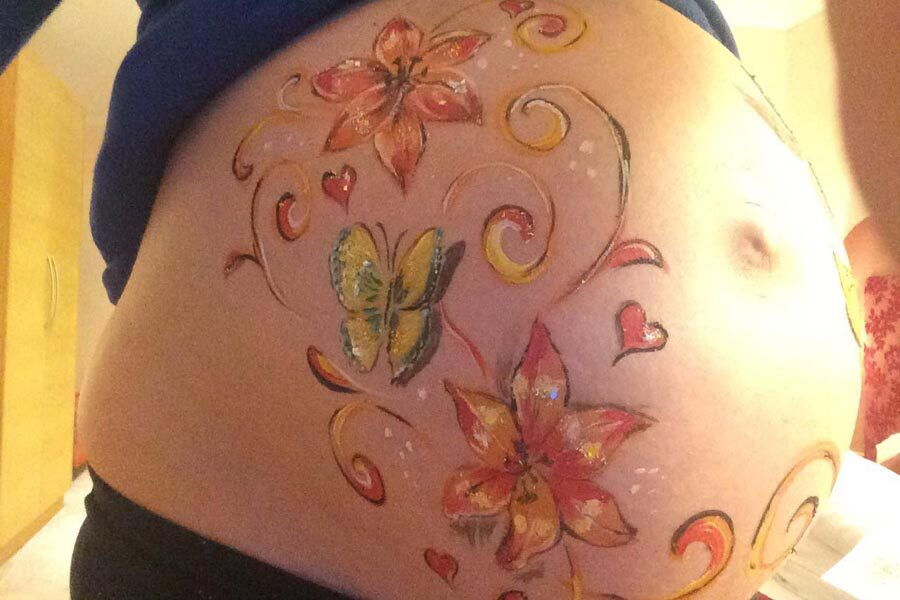 Ein Babybauch auf den Blumen und Schmetterlinge gemalt wurden.