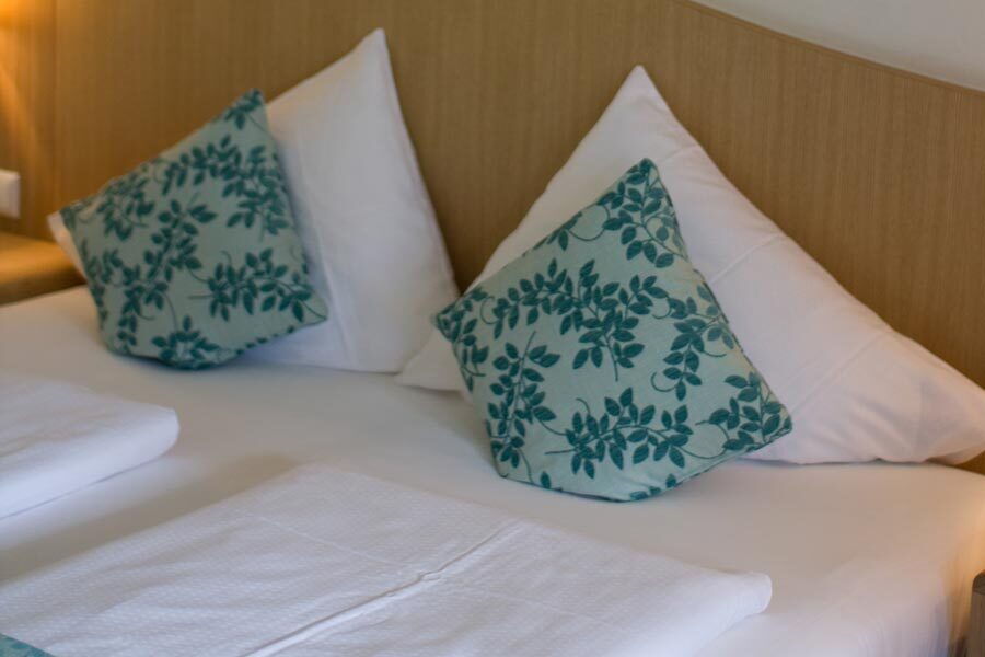 Gemütliches Bett mit dekorativen Kissen in einer Spa-Umgebung zur Entspannung und Erholung
