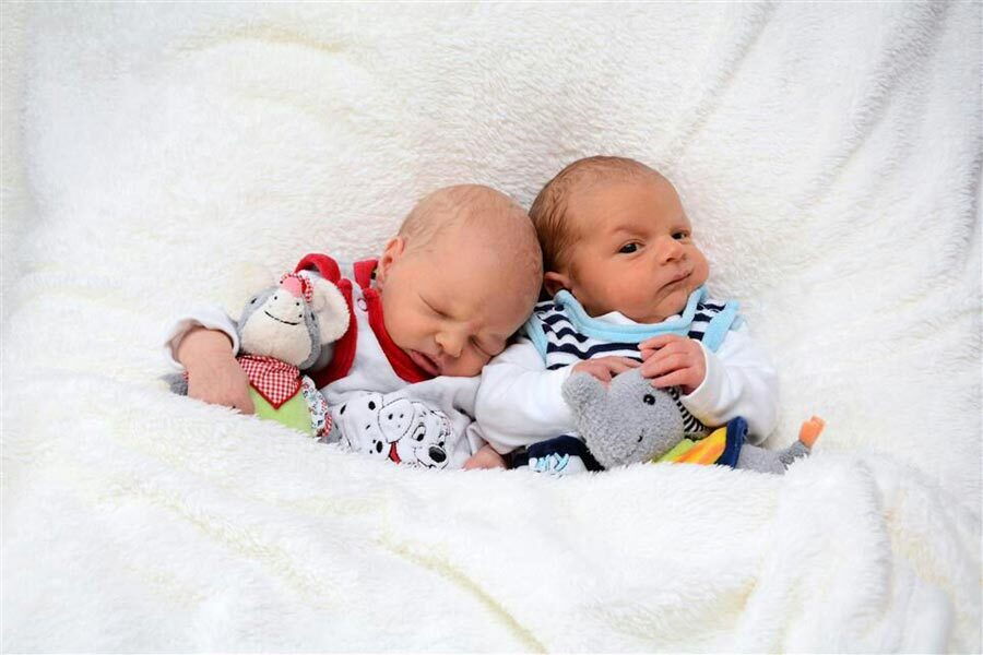 I piccoli Lena e Leon sdraiati l'uno accanto all'altro in una coperta con i loro peluche.