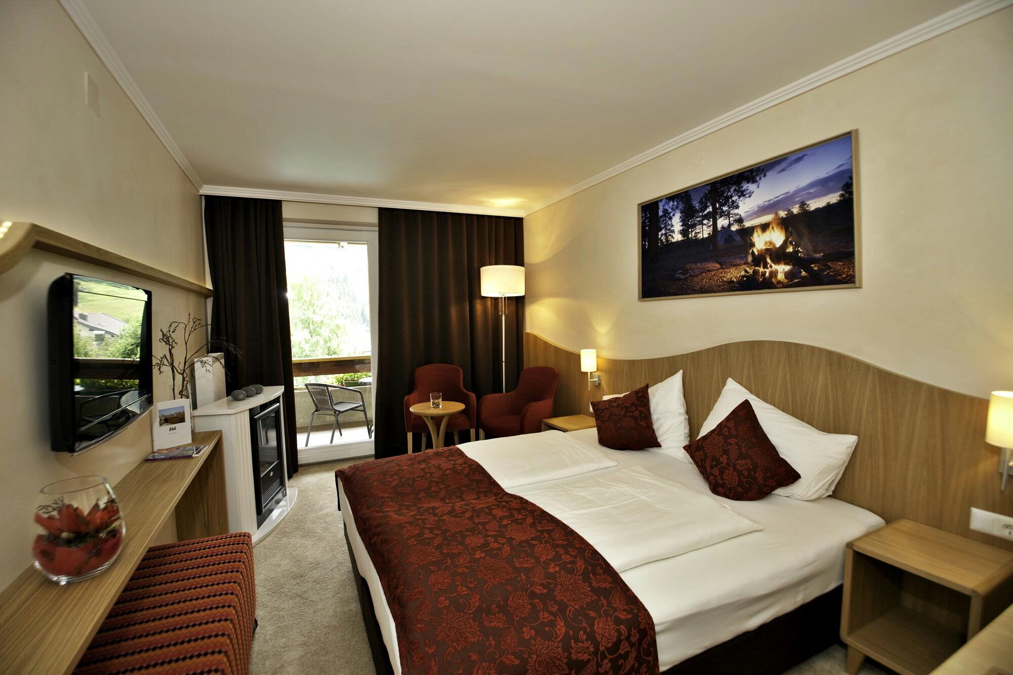 Gemütliches Spa Zimmer mit Sitzbereich und großen Fenstern für viel Tageslicht. Ideal zum Entspannen.
