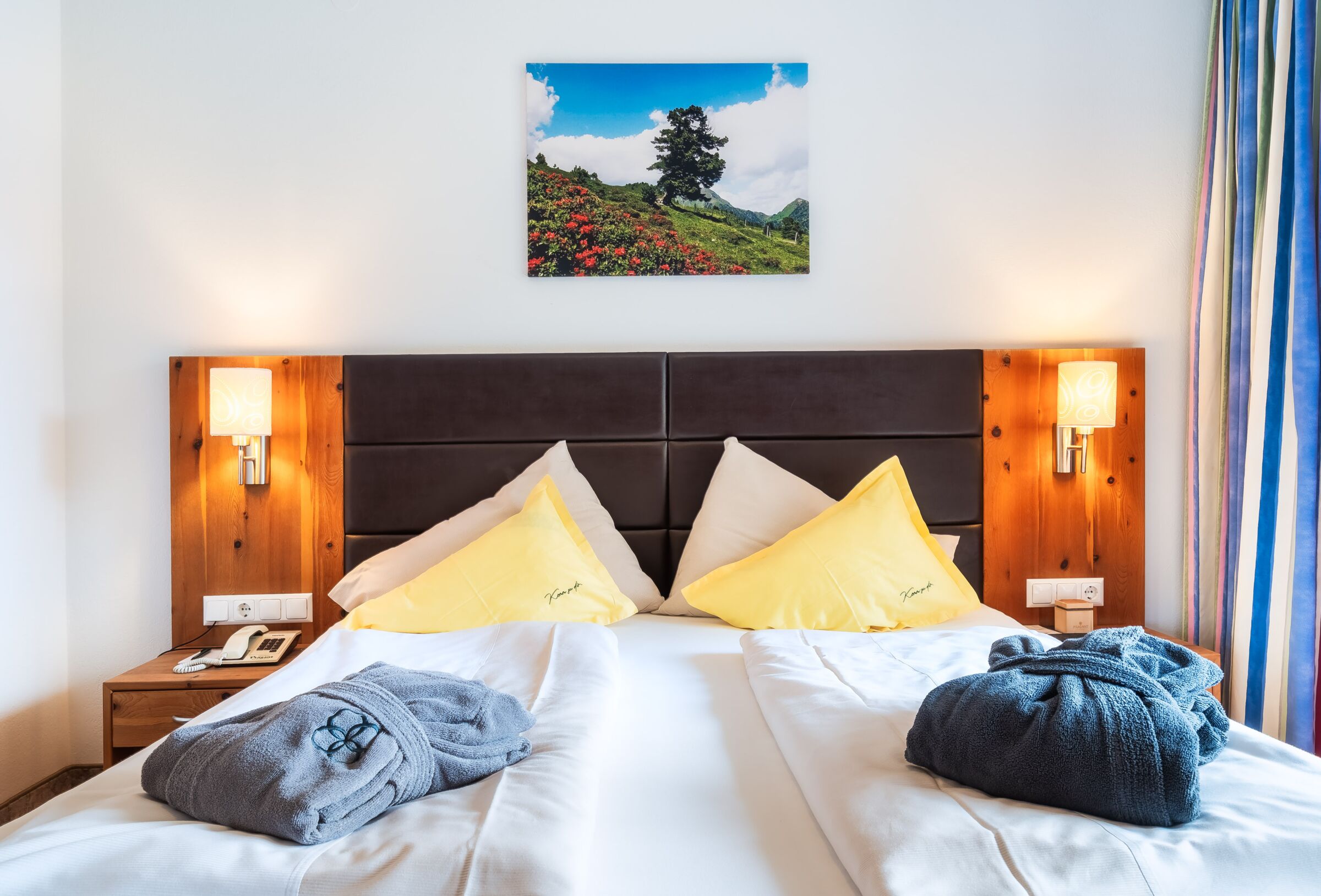 Gemütlicher Spa Raum mit Doppelbett und weichen Roben auf dem Bett für Entspannung