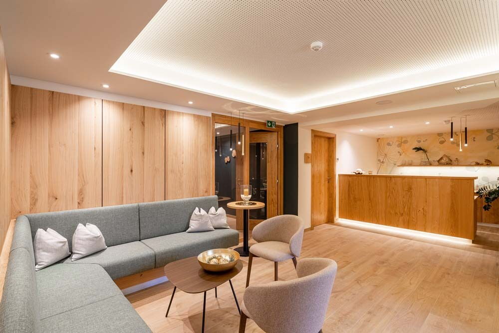 Eleganter Empfangsbereich im Wellnesshotel mit gemütlichem Sitzbereich und hellem Holzdesign