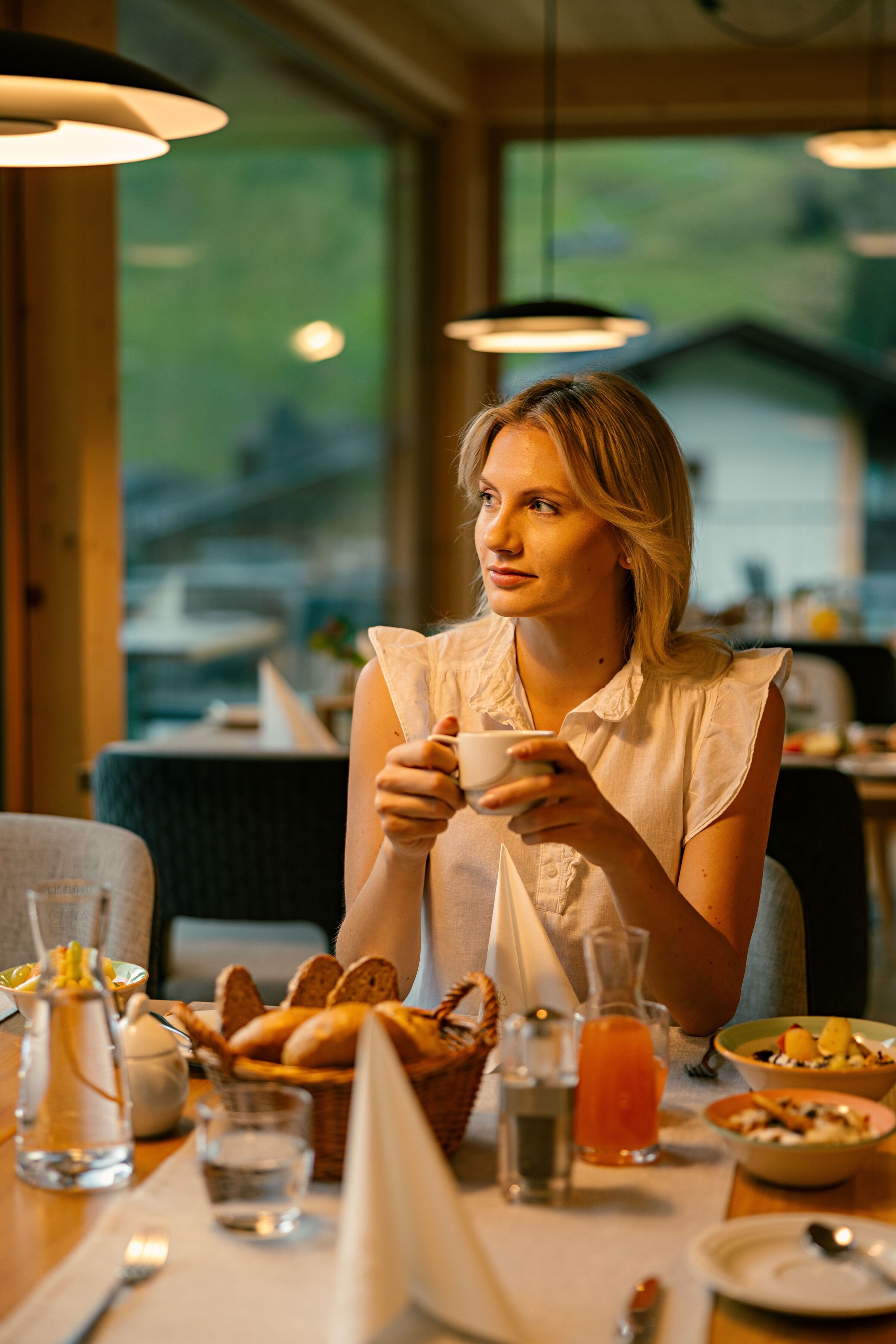 Frau genießt ruhige Atmosphäre bei einem gesunden Frühstückstisch im Spa-Bereich