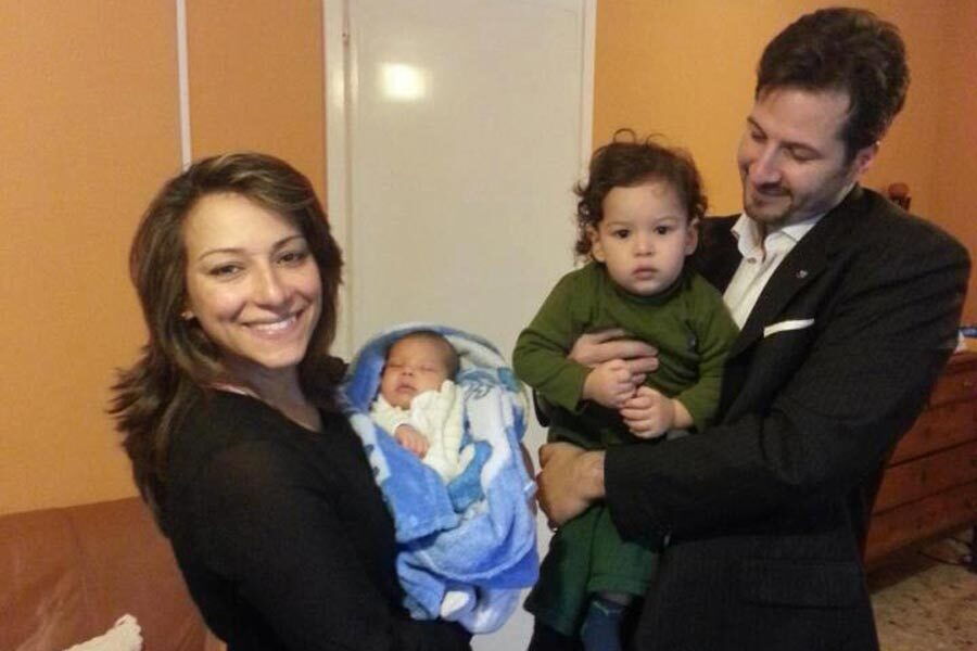 I piccoli Andrea e Raul in braccio ai genitori.