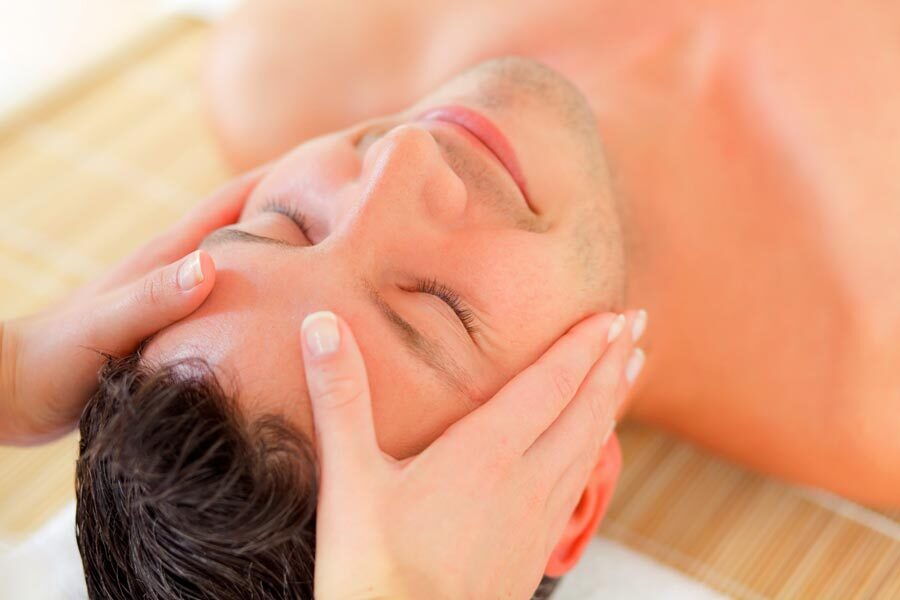 Mann erhält eine Gesichtsmassage in einer Spa-Umgebung für Entspannung und Selbstpflege