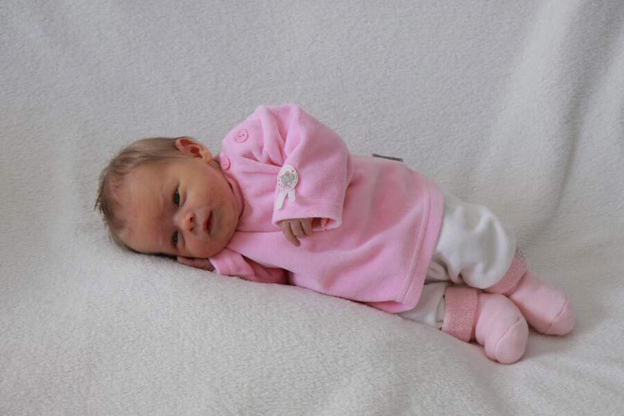 La piccola Victoria sdraiata su una coperta.