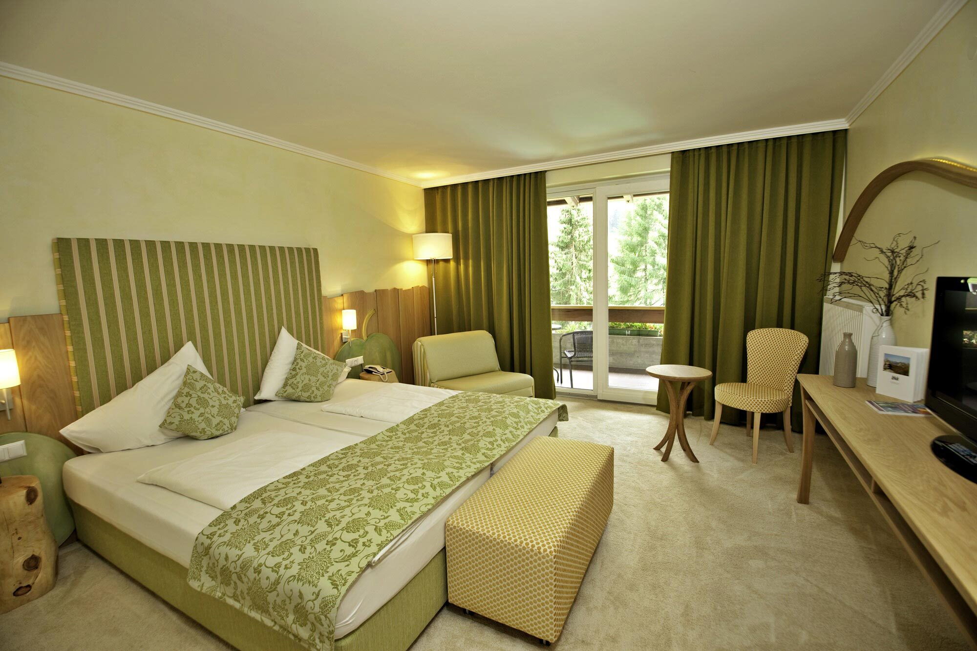 Spa Raum mit Doppelbett und Sitzecke in hellem Ambiente, ideal zum Entspannen und Wohlfühlen