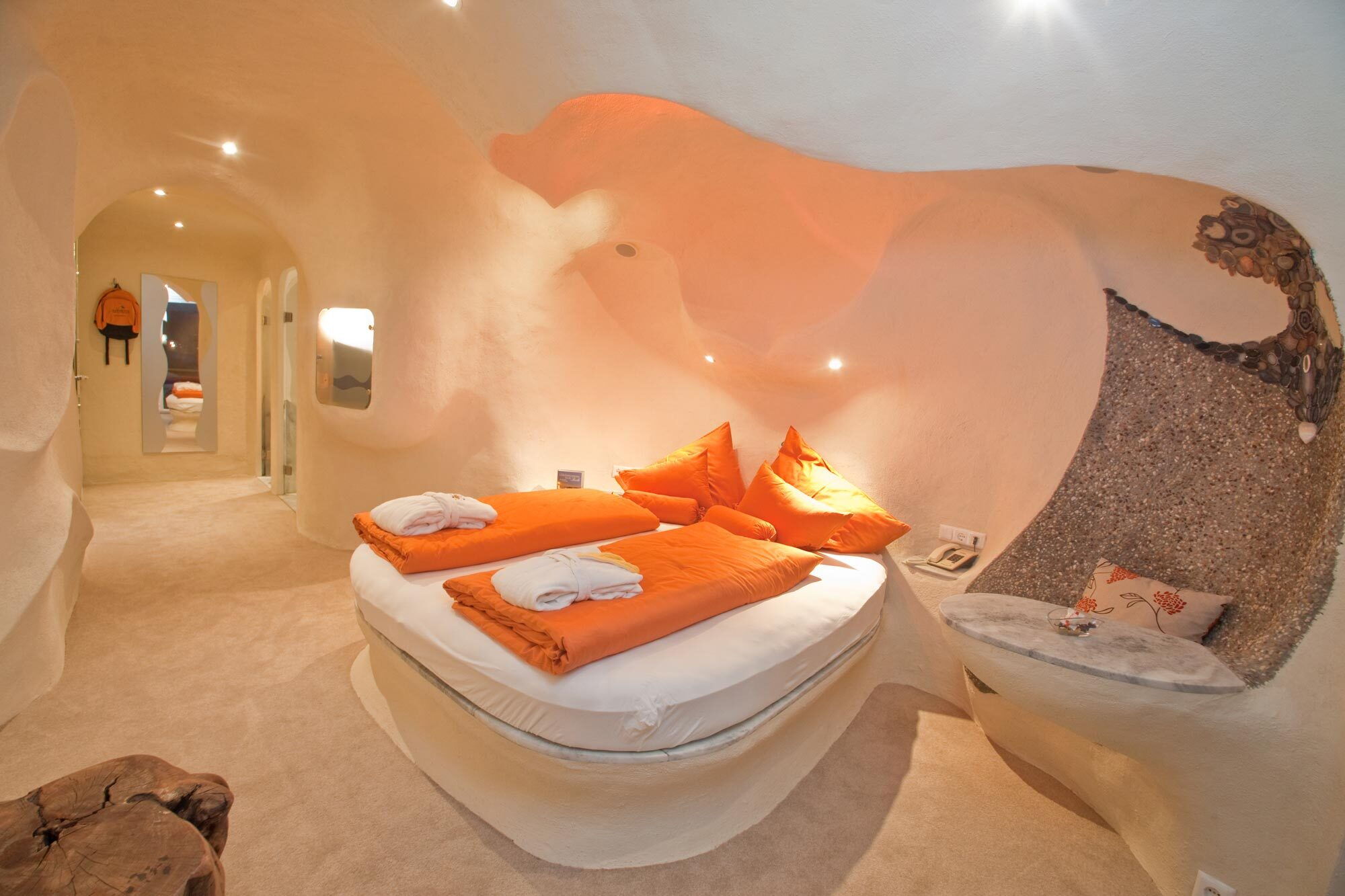 Wohlfühlbereich mit einem Bett, weicher Beleuchtung und organischen Formen der Architektur