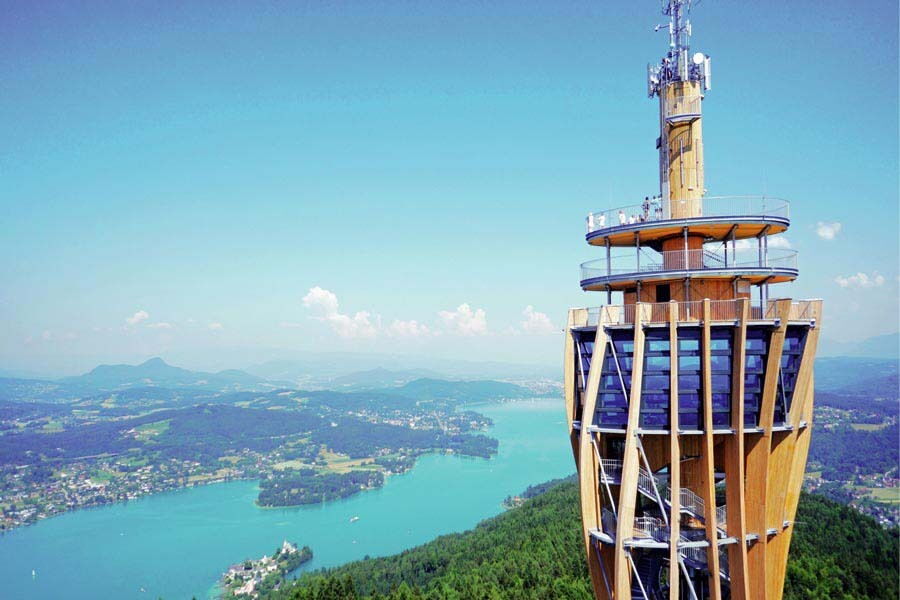 Aussichtsturm über Wasser und Hügel in Kärnten, umgeben von herrlicher Landschaft.