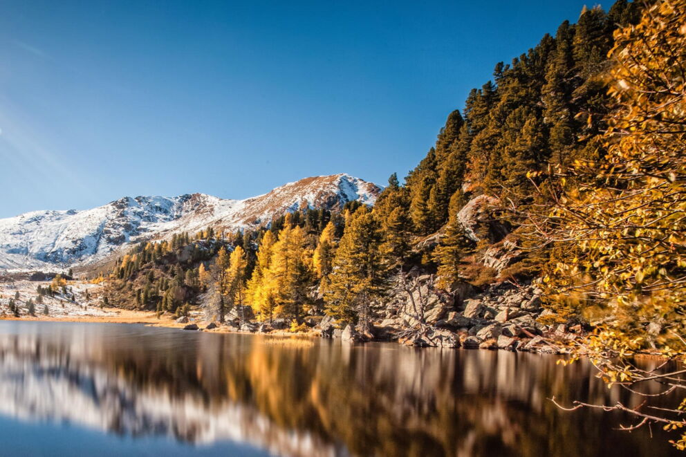Golden beleuchteter Berg im herbstlichen, leicht verschneiten Kärnten - ideal zum Wandern im Herbst.