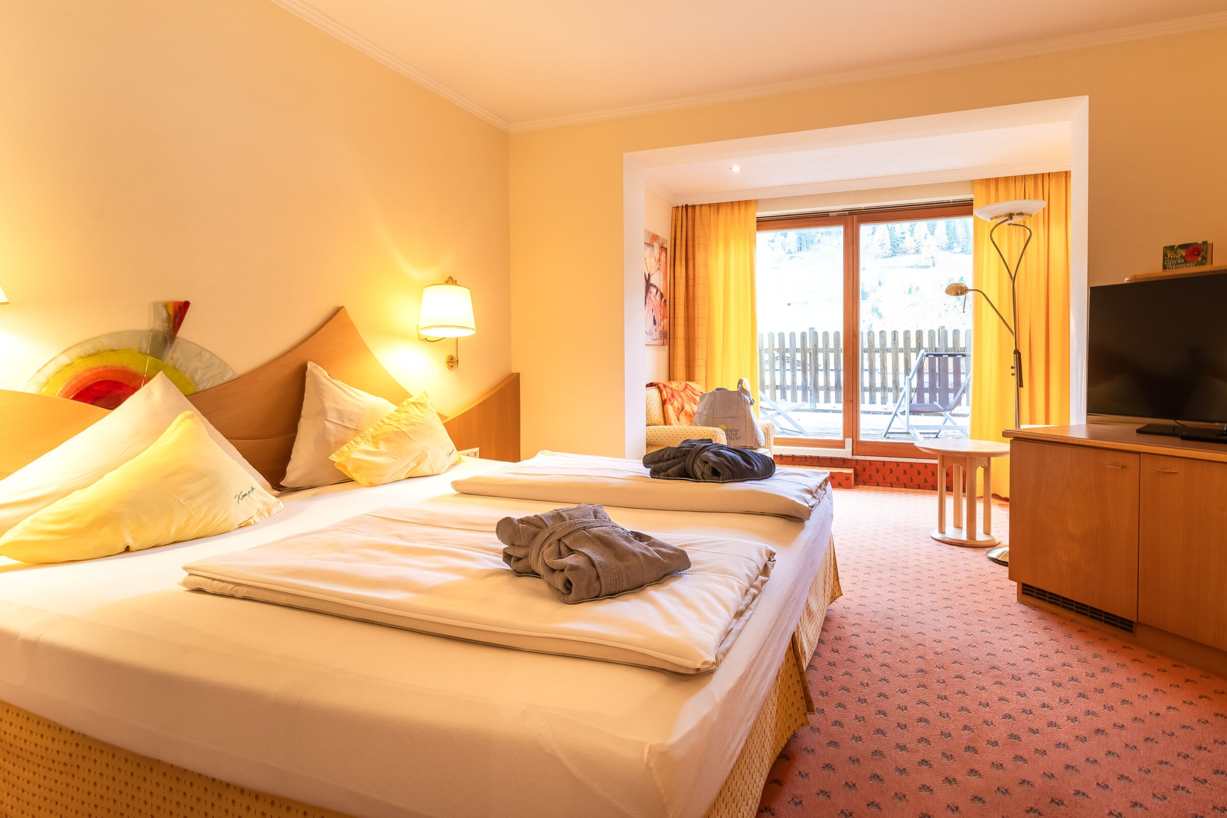 Gemütlicher Spa-Raum mit Doppelbett und sanfter Beleuchtung für Entspannung und Wohlbefinden