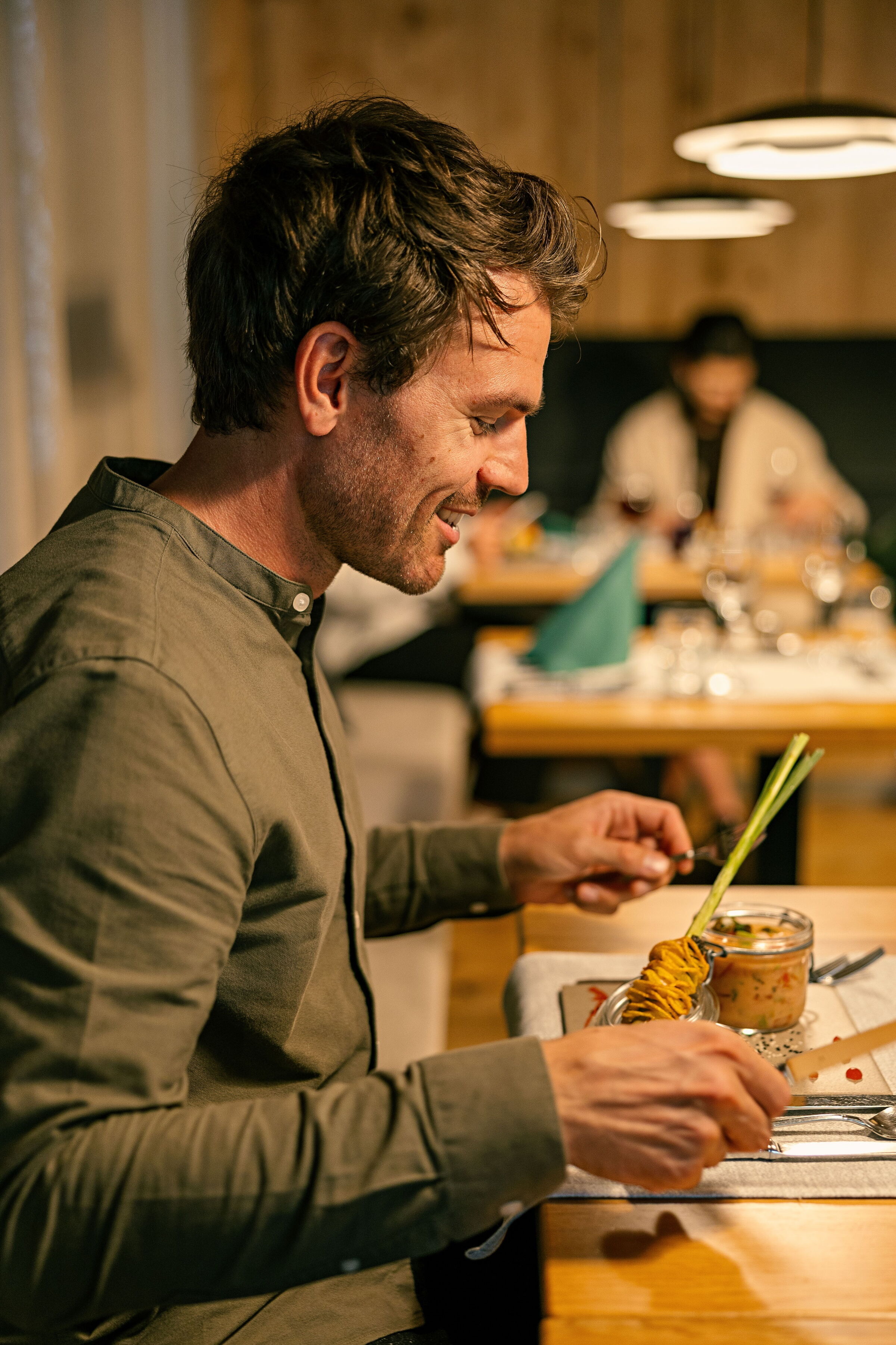 Mann genießt eine exquisite Mahlzeit in eleganter Atmosphäre eines Restaurants mit Wellnessangeboten.