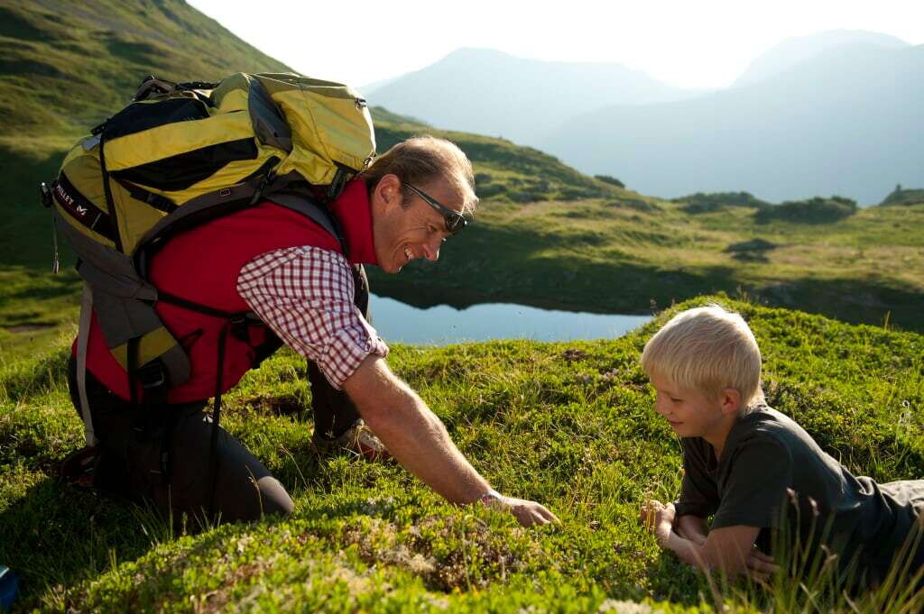 Mann und Kind erkunden die Natur in einer bergigen Landschaft während einer Outdoor-Aktivität.