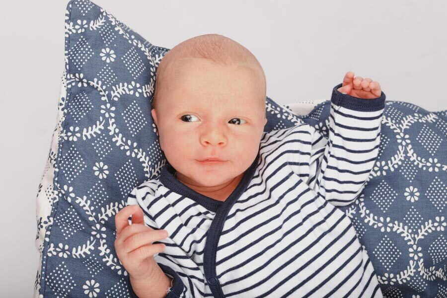 Il bambino Mattia sdraiato su un cuscino.