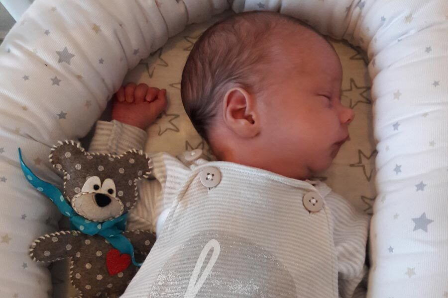 Il piccolo Tim si addormenta nel suo letto con un orsacchiotto accanto.