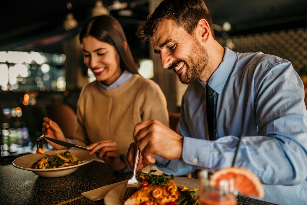 Ein Paar genießt ein gesundes Essen am Tisch in entspannter Atmosphäre im Wellnesshotel.