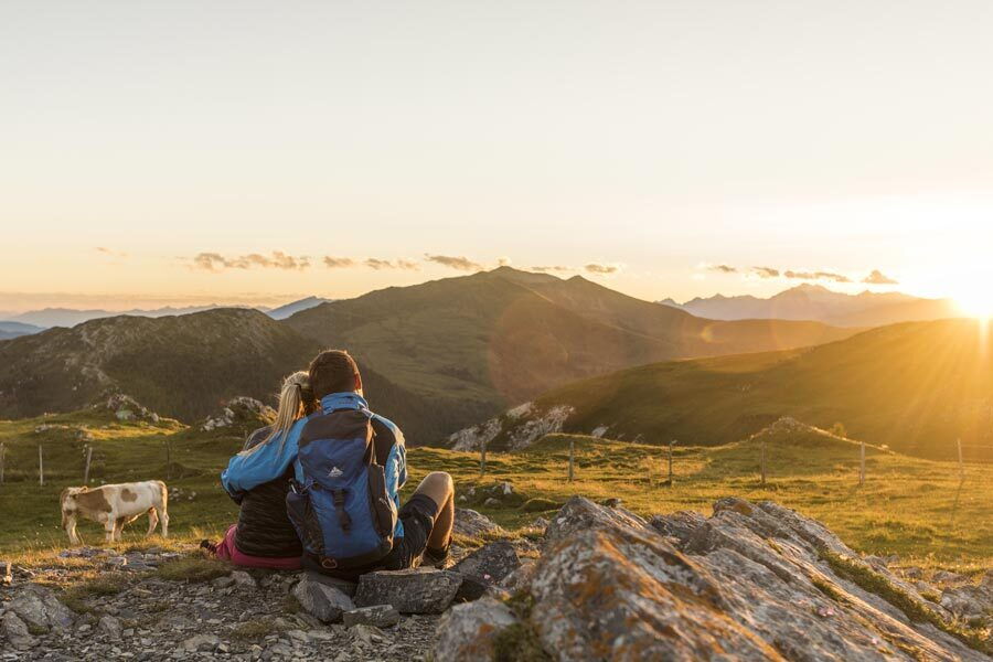 Couple lying in each other's arms on an alpine meadow in the Carinthian Alps during a wonderful sunset.