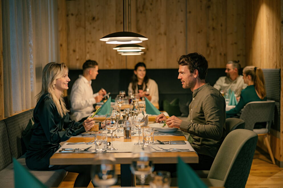 Romantisches Abendessen in einem Spa-Restaurant mit Paaren an eleganten Tischen.