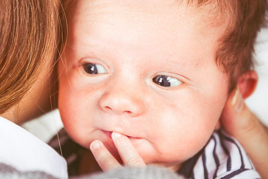 Baby Ben being hugged by his mum.